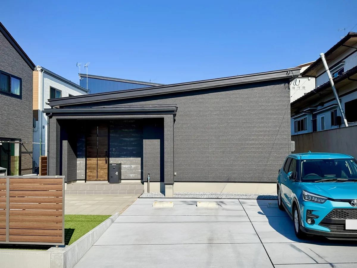 ダークグレーの外壁と木の玄関の平屋|知性と安らぎが共鳴する平屋